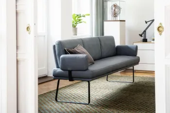 Blaue Esszimmerbank mit Lederbezug mit Armlehne und schwarzem Metallgestell in einem hellen Esszimmer.