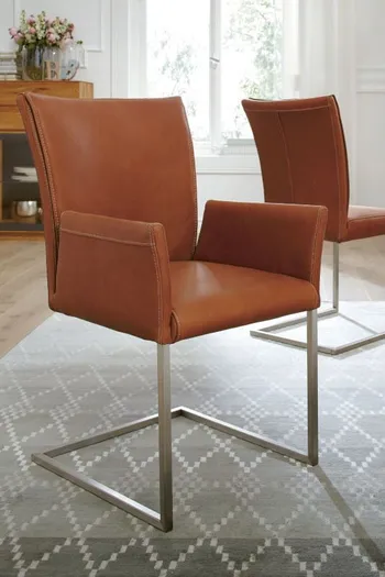Freischwinger Stuhl mit Lederbezug in orange und silbernem Fußgestell.