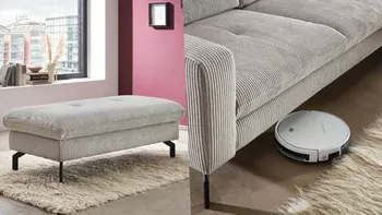 Hellgrauer Stoffhocker und Stoffsofa mit Platz für einen Staubsaugerroboter. 