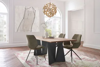 Design Esstisch mit Tischplatte aus Eichenholz und schwarzem Tischgestell in einem hellen Esszimmer einer Altbauwohnung.