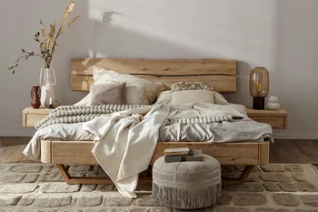 Bett aus Massivholz mit heller gemütlichen Kissen und Decken dekoriert.