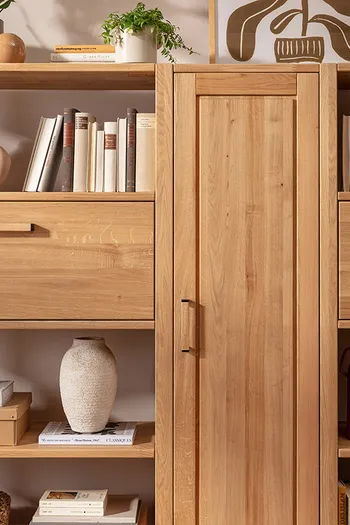 Detailaufnahme von Highboard aus massivem Eichenholz, dekoriert mit Büchern, Vasen und Pflanzen.