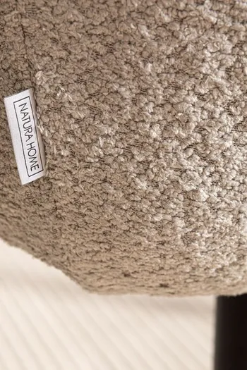 Grauer Stoff eines Esszimmerstuhls mit Natura Home Label in der Nahansicht.